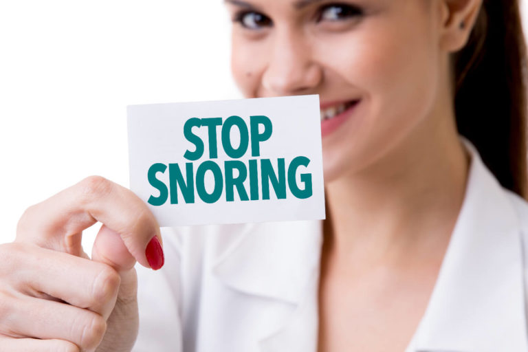 women-holding-stop-snoring-sign