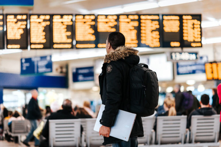 man-in-airport-reading-flight-display